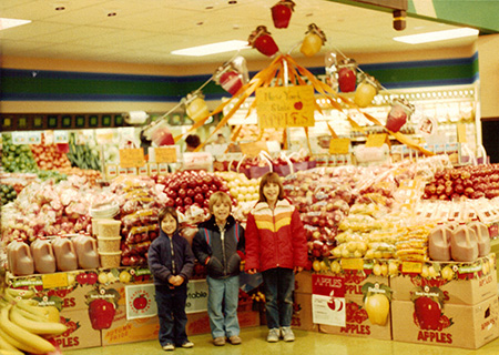 Four-year-old Pete in front of his father’s apple display